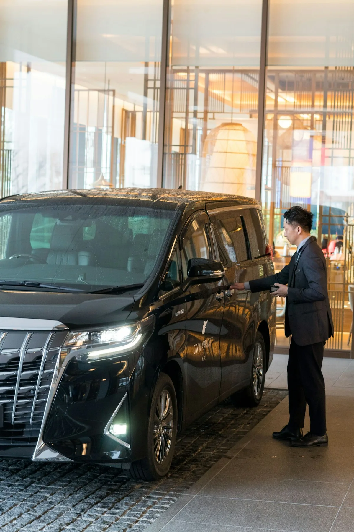 Chauffeur opening the door of a premium people mover